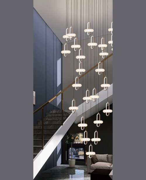 Merdiven duvarı boyunca sarkan, bakır tonlu halkalı ve kristal opal başlıklı U100×400 cm avizenin yakın plan görünümü